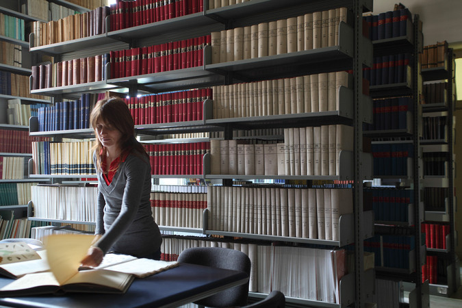 A person in a library consulting some books.